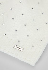 Sciarpa bianca lavorata a maglia con motivo a diamante, decorata con strass argentati e una piccola targhetta metallica con la scritta "Wittchen" in rilievo.