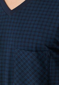 T-shirt bleu marine à col en V, fabriqué dans un tissu doux, avec un motif à carreaux et des lignes bleu clair, comportant une poche diagonale sur la poitrine gauche.