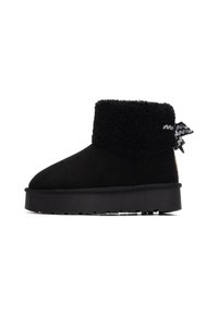 Botín negro hasta el tobillo con un upper suave y texturizado, un collar esponjoso y un acento de cinta en contraste en la parte posterior, con una suela gruesa.