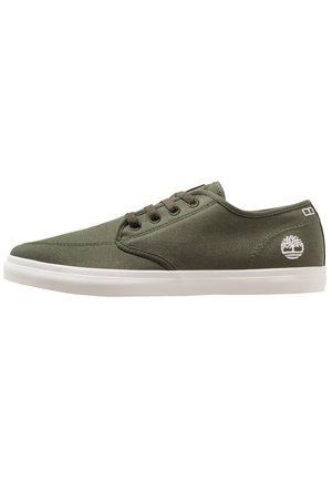 Low-top casual sneaker in olive green canvas with dark laces, white rubber sole, and white tree logo on heel side.