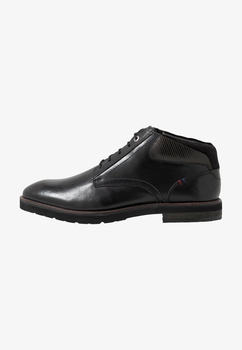 Bottine en cuir noir avec lacets sur le devant, talon bas, finition lisse et détails de couture subtils près de la cheville.