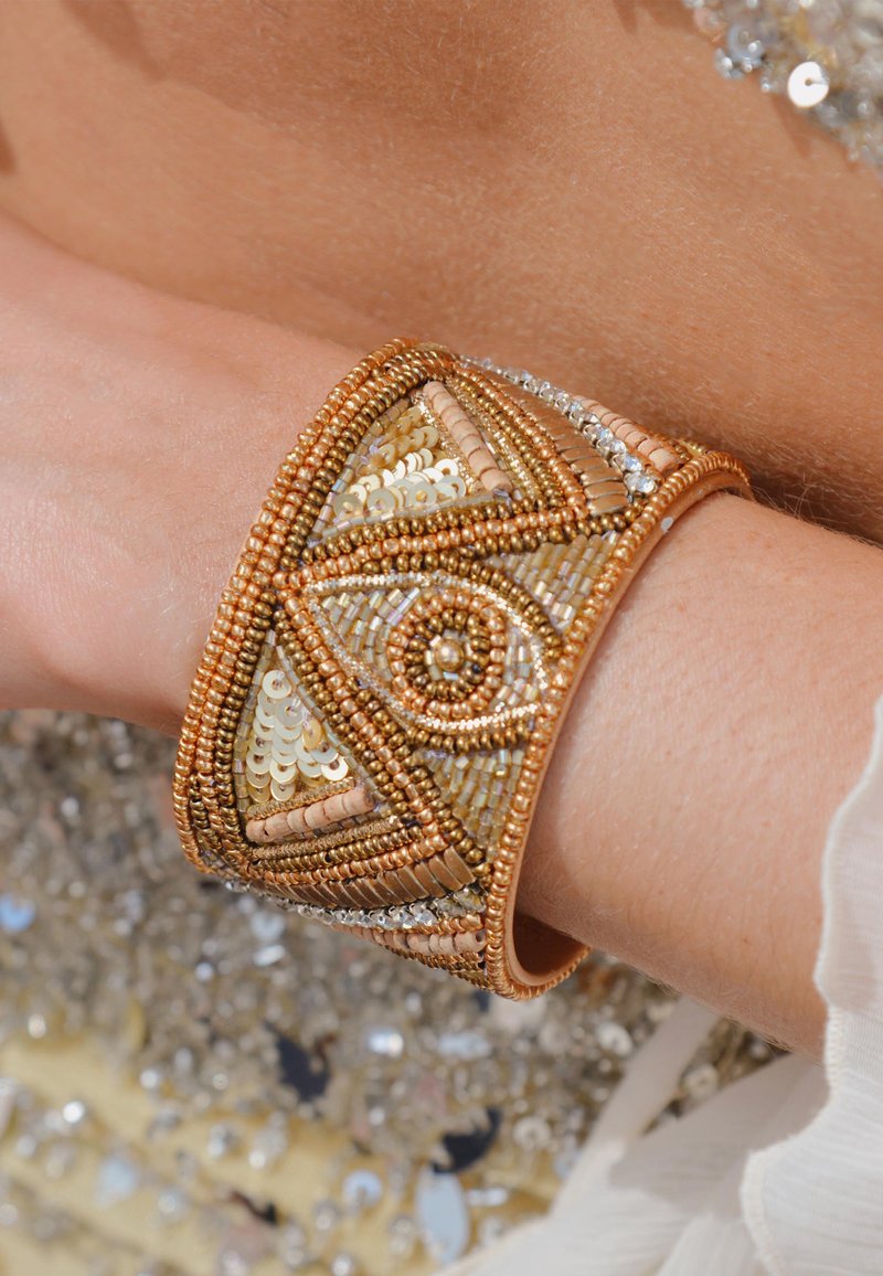 Bracelet manchette perlée en tons or, bronze et argent. Design géométrique avec des sequins et des motifs de perles complexes.