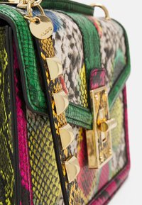 Farverig, struktureret crossbody taske med slangeprintmønster, der har guldbeslag, en dekorativ kædestrop og en låseklap.