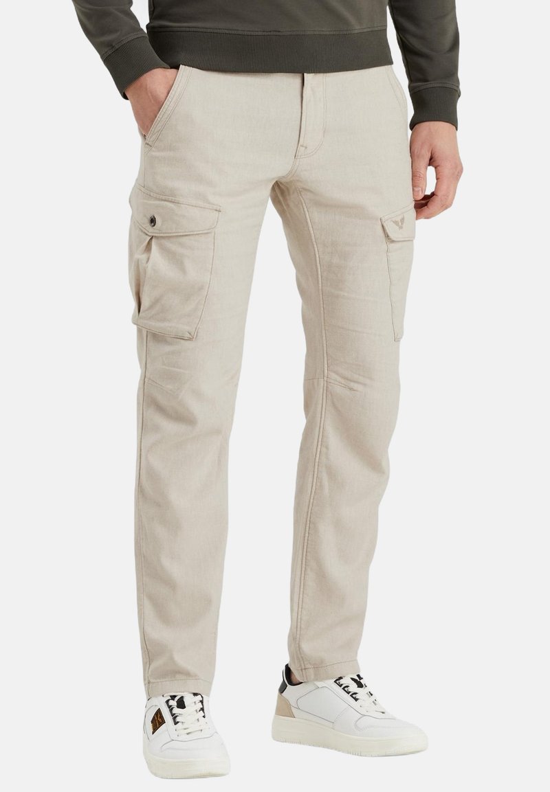 Pantalones cargo beige con dos bolsillos laterales, corte recto, detalles de costura y una textura suave. Combinado con zapatillas blancas.