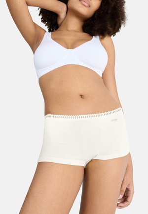 Witte katoenen beha en crèmekleurige shorts met een gekartelde kantafwerking. Zachte textuur, aansluitend ontwerp dat de taille accentueert. Logo op de shorts gedrukt.