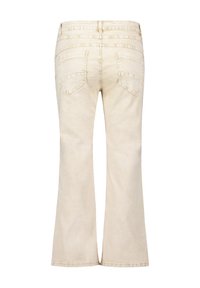 Jean beige évasé à taille haute, en denim. Comprend deux poches arrière et des détails de couture discrets le long de l'empiècement.