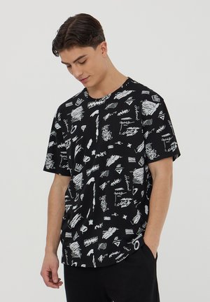 T-shirt nero a maniche corte con un motivo astratto bianco a doodle. Collo a giro e vestibilità rilassata con una morbida texture del tessuto.