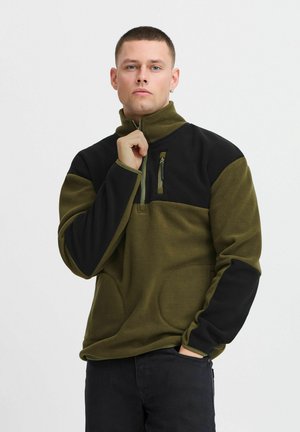 Fleece pullover in olive green and black, featuring a zippered collar, chest pocket, and side pockets with a smooth texture.