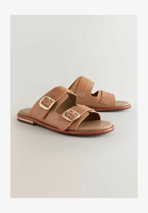 Sandales à glissière en cuir brun avec deux larges brides ornées de boucles en or ; semelle lisse, pointe arrondie et un petit talon en bois.