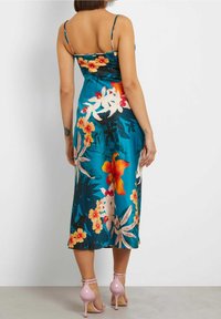 Teal väksy satin midi-dress, joka on koristeltu oransseilla ja vaaleanpunaisilla kukilla, olkaimeton ja istuva yläosa. Yhdistetty vaaleanpunaisiin remmi-korkokenkiin.