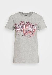 Camiseta de algodón gris de manga corta, con un diseño floral colorido y el texto "Lujo" en blanco en la parte frontal. Textura suave.
