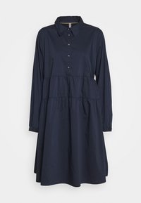 Marinblå skjortklänning med långa ärmar och en sammanknuten flerfaldig design, tillverkad av ett slätt tyg. Har krage och manschetter.