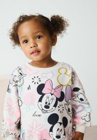 Valge kapuutsiga dressipluus, millel on värvikas trükk Disney tegelastest, sealhulgas Minnie Mouse ja Donald Duck, koos lille- ja südame mustritega.