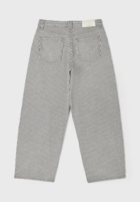 Pantalon taille haute à larges jambes avec rayures verticales noires et blanches et deux poches arrière.