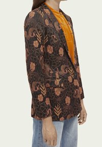 Czarna marynarka z ozdobnym wzorem kwiatowo-wężowym w odcieniach pomarańczowego i złotego. Teksturowany materiał, slim fit, klapy o wycięciu w kształcie litery V oraz zapięcie na jeden guzik.