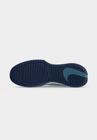 Σόλα από σκουρόμπλενο παπούτσι Nike με υφή μοτίβου κατάλληλο για λαβή και λογότυπο Nike Swoosh σε ανοιχτό μπλε κοντά στη φτέρνα.