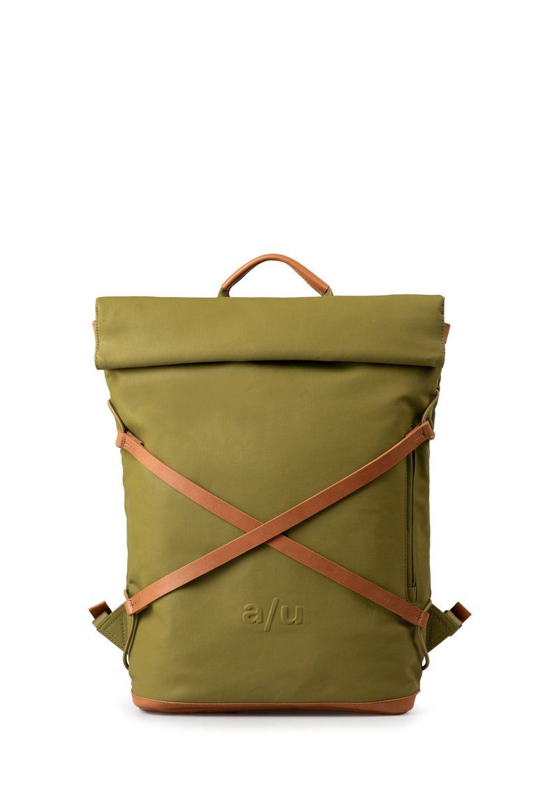 Zaino verde oliva con chiusura roll-top, dettagli in pelle marrone e cinghie incrociate. Presenta un logo impresso e un dettaglio con zip laterale.