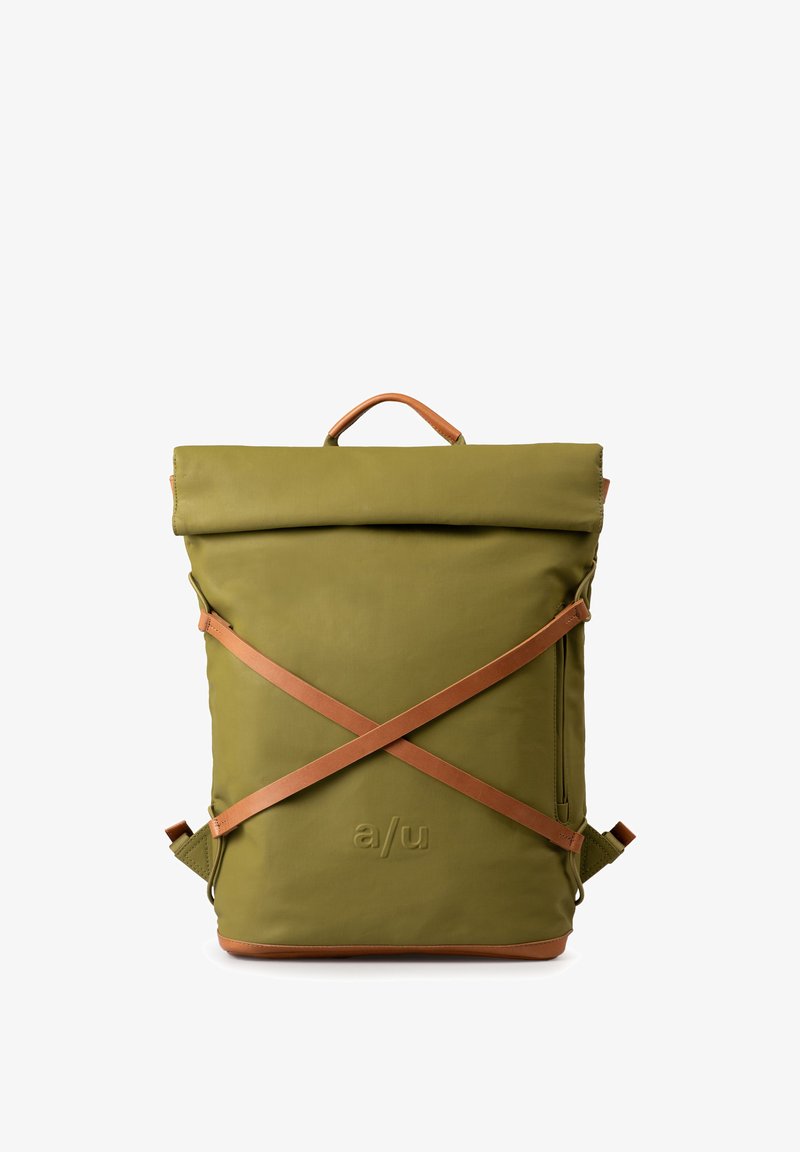 Olijfgroene rugzak met een rol-top sluiting, tan lederen accenten en kruisstropen. Voorzien van een gegraveerd logo en een ritsdetails aan de zijkant.