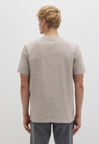 Short-sleeve, light beige t-shirt with subtle horizontal stripes, crew neckline, and a relaxed fit. Made from soft cotton-blend fabric.