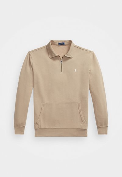 Sweatshirt beige à manches longues avec fermeture éclair quart, poche kangourou à l'avant et petit logo brodé blanc sur la poitrine.