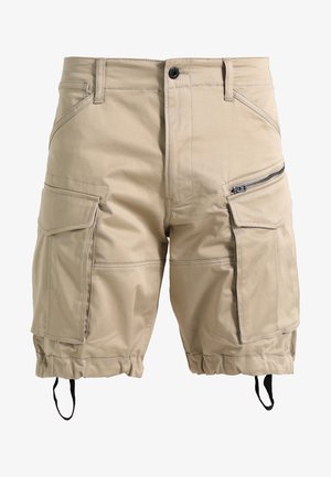 Pantaloni cargo beige realizzati in un materiale leggero. Presentano molteplici tasche, una tasca laterale con zip e aperture delle gambe regolabili.