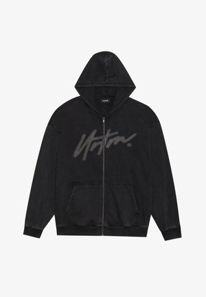 Melns zip-hoodijs ar priekšējo kabatu, kuram ir liels pelēks apdrukāts logs krūšu daļā. Izgatavots no mīksta, teksturēta auduma.