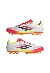 Kevyet jalkapallokengät, joissa on valkoinen päällinen punaisilla ja keltaisilla yksityiskohdilla, tekstuuripinta ja musta brändäys. Piikkipohja pitoa varten.