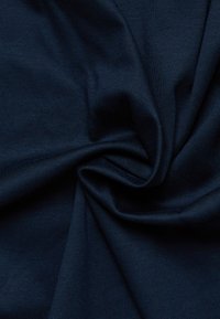 Navyblauwe stof met een gladde textuur, met een gedraaide plooi die het gewicht en de val ervan benadrukt.