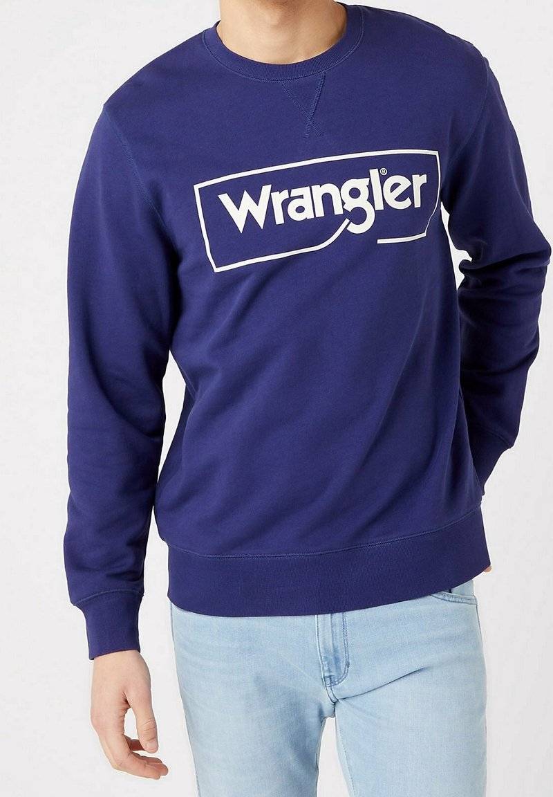 Sweat-shirt bleu marine en coton, avec logo "Wrangler" blanc sur le devant, poignets et ourlet côtelés, et col rond classique.