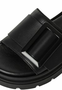 Zwarte sandalen met een brede, gladde leren band en een rechthoekige glanzende gesp, een gestructureerde voetbed en een chunky rubberen zool.