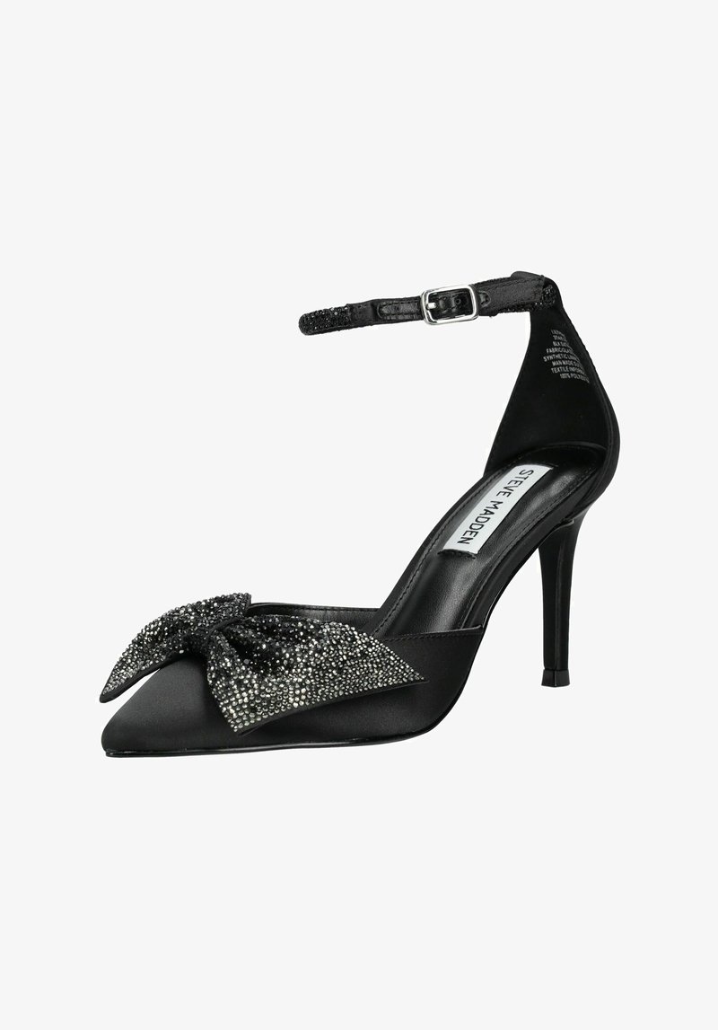 Escarpin en satin noir avec un embout pointu, un nœud orné de strass, une bride de cheville et un talon aiguille. Surface au toucher lisse.