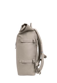Mochila de tapa enrollada en tejido beige claro, con correas ajustables, bolsillo exterior y panel de malla para transpirabilidad.