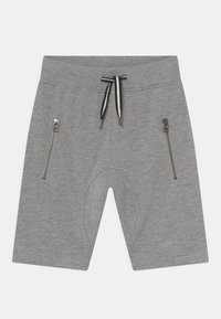 Pantalones cortos deportivos grises, hechos de una tela suave, con bolsillos laterales con cremallera y una cinturilla ajustable con cordón en contraste negro.