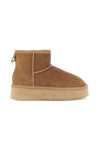 Stivale alla caviglia in suede marrone con suola in gomma piatta, tassello sul retro e cuciture visibili, isolato su sfondo bianco.