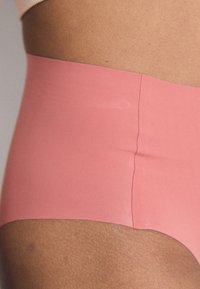 Magas derekú rózsaszín fehérnemű sima anyagból, varrat nélküli kialakítással és puha, rugalmas derékpánttal a kényelemért.