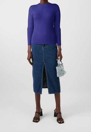 Violetti, ribbineulottu pitkähihainen paita kulmikkaalla designilla, yhdistetty farkkuhameeseen, jossa on etuhiha. Asusteina vaaleansininen käsilaukku.