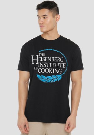 Schwarzes Baumwoll-T-Shirt mit einem kreisförmigen Design, das "Das Heisenberg Institut für Kochen" in weißen und blauen Buchstaben zeigt, verziert mit blättrigen Akzenten.