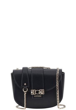 Bolso cruzado de cuero negro con cierre de solapa, correa de cadena plateada y un destacado acento de logo en el frente. Textura suave, forma compacta.