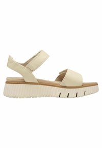 Beige open-toe sandal with two adjustable straps and a thick white ridged sole.