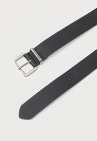 Zwarte leren riem met een zilverkleurige rechthoekige gesp, vijf gaatjes voor aanpassing en een puntige uiteinde op een witte achtergrond.