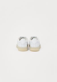 Λευκά δερμάτινα sneakers με υφή, διαθέτοντας κρεμ καουτσούκ σόλα και επενδεδυμένη φτέρνα. Η ετικέτα "The Club C" στη φτέρνα.