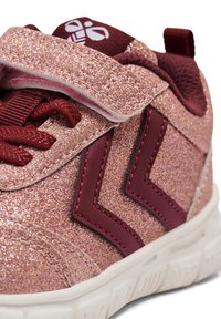 Różowe sneakersy z brokatem, z rzepem, z bordowymi akcentami i teksturowaną powierzchnią. Zauważalny detal w postaci zygzakowatego przeszycia. Gumowa podeszwa.