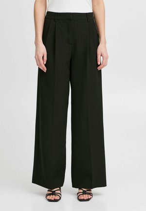 Black wide-leg pants made of smooth fabric, featuring pleats at the front and a tailored fit. Worn with strappy black sandals.