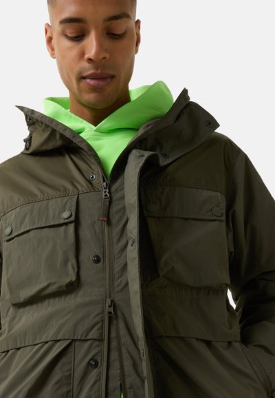 Olive green, water-resistant jacket with a hood, zip front, two chest pockets, and button closures. Layered over a bright neon green hoodie.