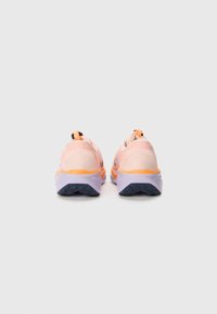 Des chaussures de sport roses avec des accents orange et violet, présentant un dessus texturé, une languette à l'arrière et une semelle en caoutchouc gris durable.