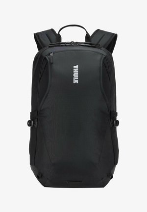 Black Thule brand backpack with padded shoulder straps, top handle, front zippered compartment, and side adjustment straps.