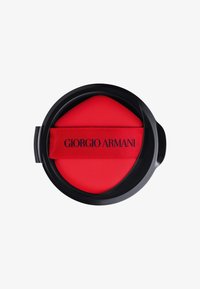Conteneur noir rond avec un intérieur doux rouge vif et un ruban en tissu rouge portant le texte "Giorgio Armani". Fini noir mat.