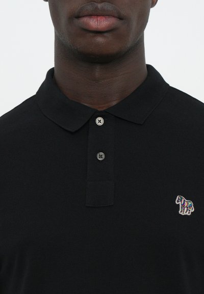 Black polo shirt featuring a classic collar, two-button placket, and a small multicolored zebra logo on the left chest.