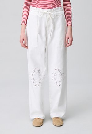 Pantalons larges blancs avec des découpes en forme de fleurs à l'ourlet, dotés d'une taille à cordon et de poches latérales.