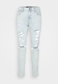 Ljusblå denimjeans med slitna hål och fransade fållar. Slim fit-design med fem fickor och knäppning i midjan.